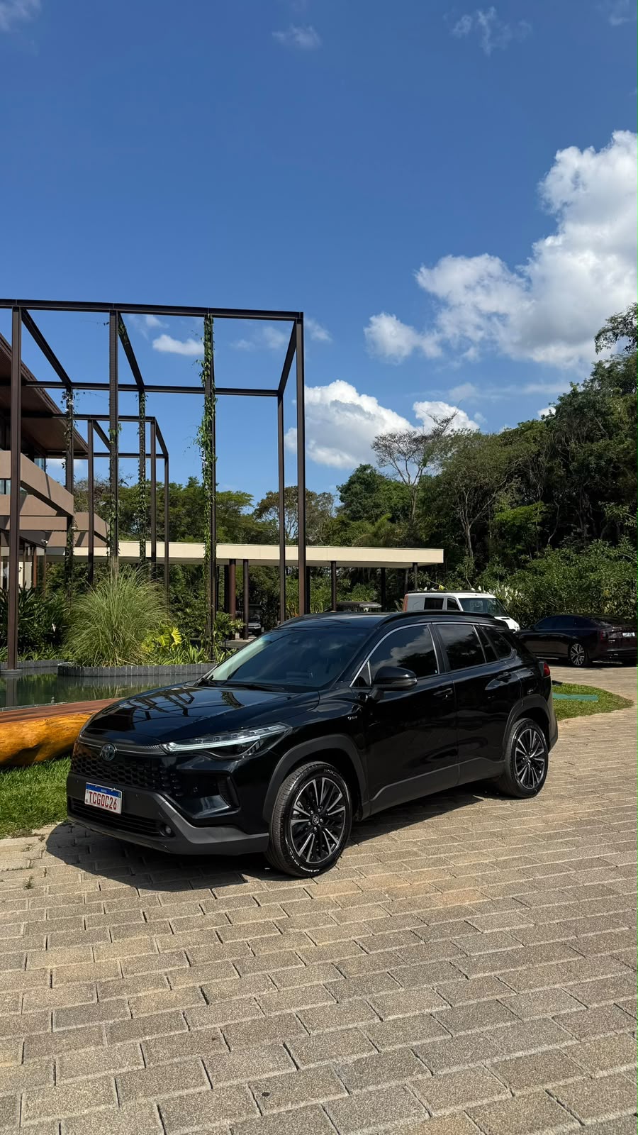 SUV executiva preta estacionada em área arborizada