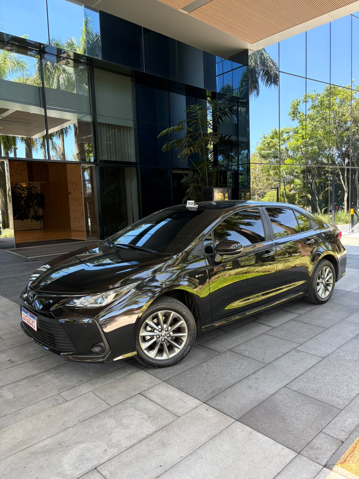 Sedan executivo preto em frente a um prédio de vidro