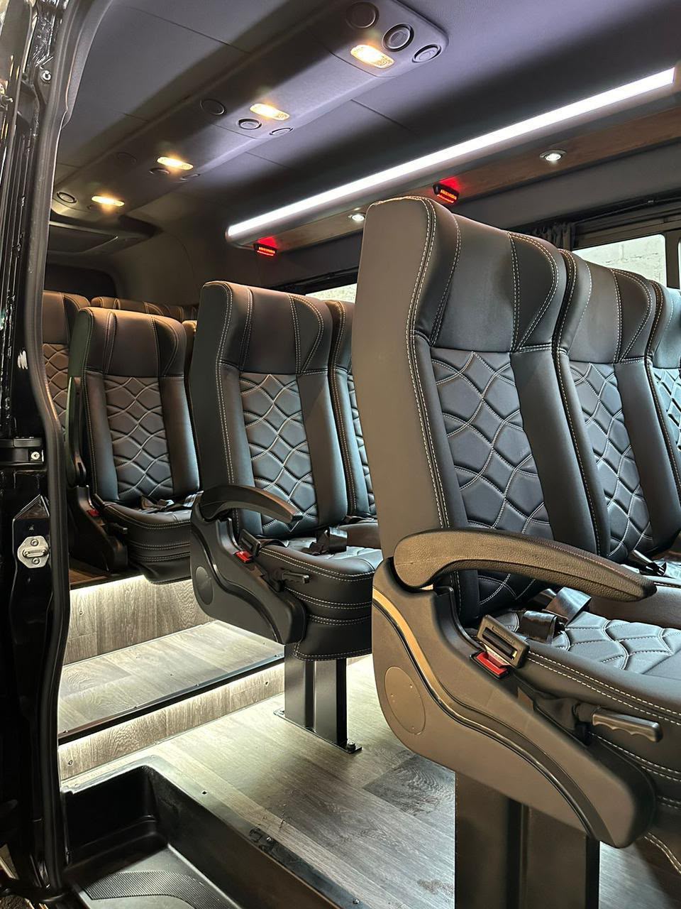 Interior de van executiva com poltronas de couro reclináveis e iluminação em LED
